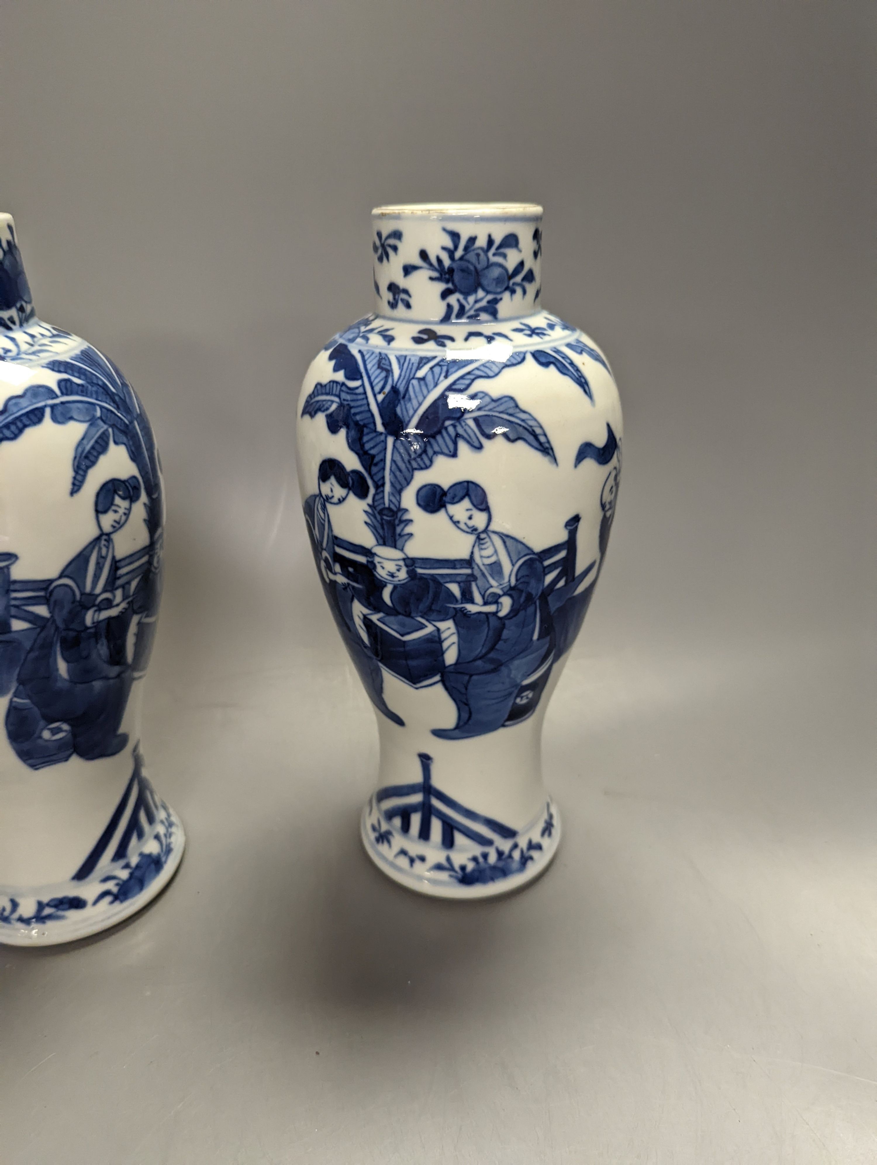 A pair of Chinese figural blue and white vases, drilled bases, height 25cm, and a plate